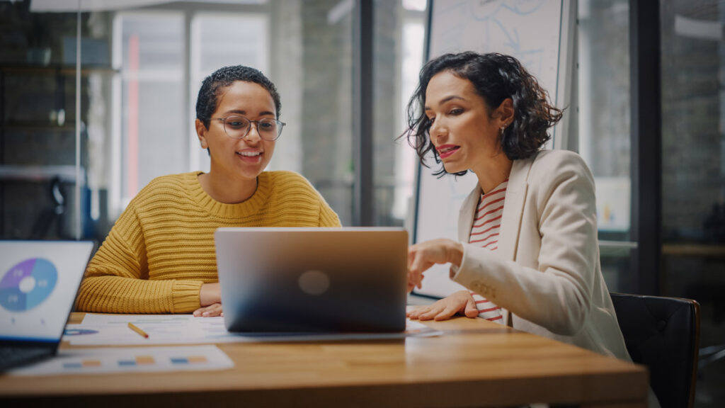 Two Diverse Females sitting behind a laptop